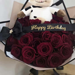 Bouquet of red roses with a plush cow and Happy Birthday ribbon