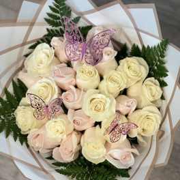 Bouquet of pale pink and cream roses with fern foliage and butterfly picks