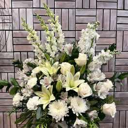 White floral arrangement with lilies, roses, and chrysanthemums in a vase
