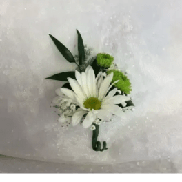 White daisy boutonniere with green accents on white fabric