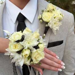 White rose boutonniere and matching wrist corsage on a light suit