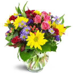 Colorful mixed bouquet of daisies, roses, and carnations in a glass vase