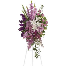 Tall purple and white floral standing spray on a white easel