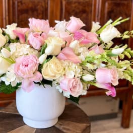 Pink and white floral arrangement in a white vase