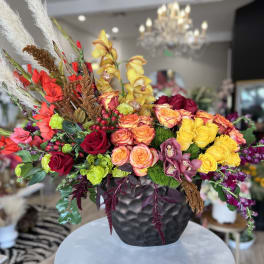 Colorful mixed flower arrangement in a black vase