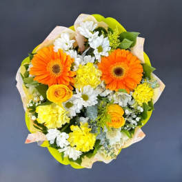 Bouquet of orange gerbera daisies, yellow roses, and white daisies