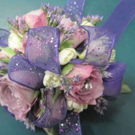 Pink and white rose bouquet wrapped with purple ribbon