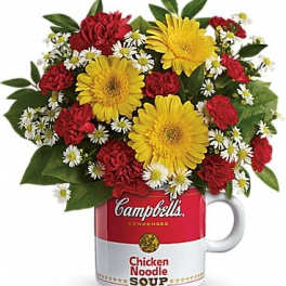 Bouquet of red and yellow flowers in a Campbell's soup mug