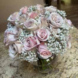 Bouquet of pale pink roses and baby's breath in a glass vase