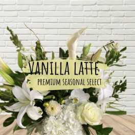 White floral arrangement with lilies, roses, and orchids