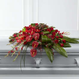 Red roses and anthuriums arranged on a casket