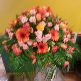 Large bouquet of orange and pink flowers with greenery