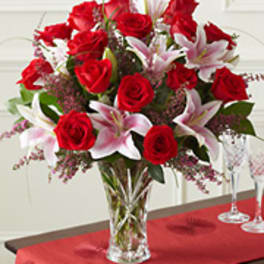 Bouquet of red roses and white lilies in a clear glass vase