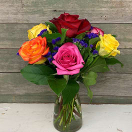 Colorful roses arranged in a clear glass vase