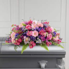 Pink and purple floral casket spray with mixed blooms