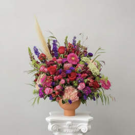 Large colorful flower arrangement in a terracotta vase