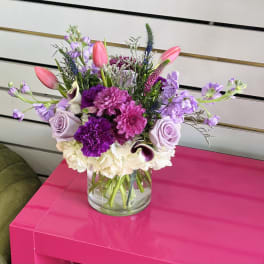 Mixed bouquet in a clear glass vase with pink, purple, and white flowers