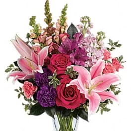 Pink lilies and roses in a clear glass vase