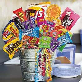 Bucket filled with assorted candy bags and curly ribbon streamers