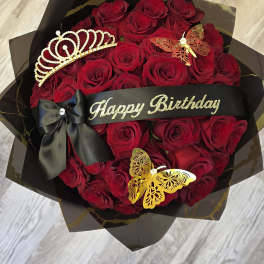 Red rose bouquet with a black birthday ribbon, bow, and decorative tiara