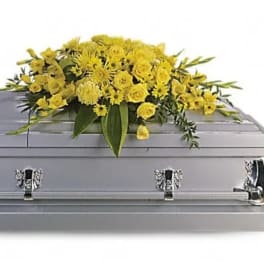 Yellow floral spray on a silver casket