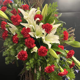 Large floral spray with white lilies and red carnations on a twig base