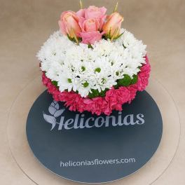 Pink roses and white daisies in a round floral arrangement