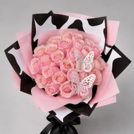 Pink rose bouquet wrapped in pink and black paper with butterfly decorations