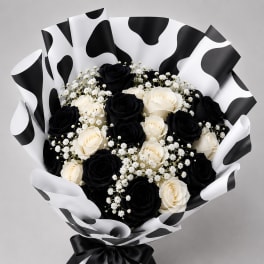 Bouquet of black and white roses with baby's breath in cow-print wrapping