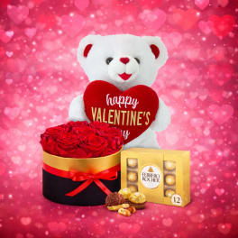 White teddy bear holding a heart with roses and chocolates on a pink heart background