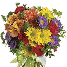 Colorful mixed bouquet in a glass vase with a green polka-dot ribbon