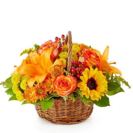 Basket of orange and yellow flowers with roses and lilies