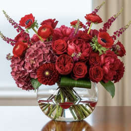 Red and pink floral arrangement in a clear glass vase