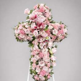 Pink floral cross on a white stand