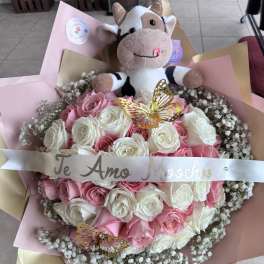 Pink and white rose bouquet with a plush cow and butterfly decorations