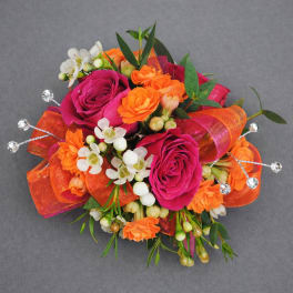 Bouquet of hot pink and orange roses with white blossoms and ribbon accents