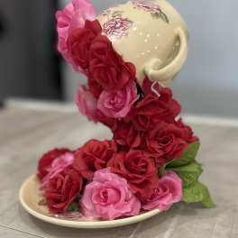 Ceramic teacup and saucer covered with pink and red roses