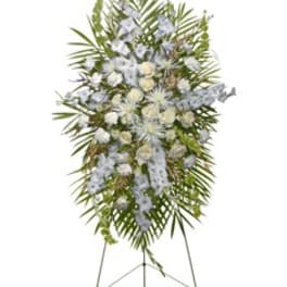 White and pale blue funeral spray on a standing easel