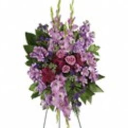 Standing spray of purple and pink flowers on an easel