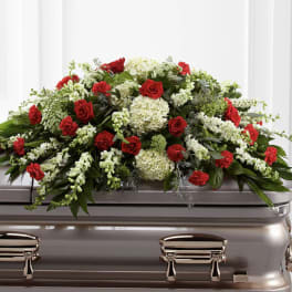 Red roses and white flowers arranged on a casket