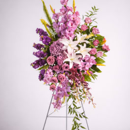 Tall floral spray with pink, purple, and white blooms on a metal stand