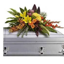 Bright floral spray on a silver casket