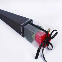 Single red rose in a clear gift box with a black ribbon bow