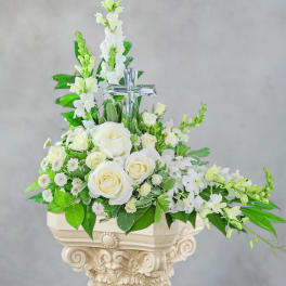 White rose and orchid arrangement with a clear cross centerpiece