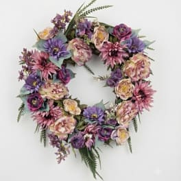 Circular floral wreath with purple, pink, and cream flowers