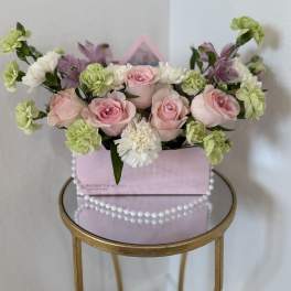 Pink roses and green carnations in a pink gift box with pearl trim