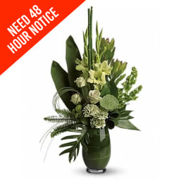 Tall green floral arrangement in a vase with white blooms