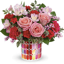 Pink roses and red carnations in a colorful mosaic vase