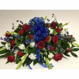 Red roses and white flowers arranged with a blue ribbon bow