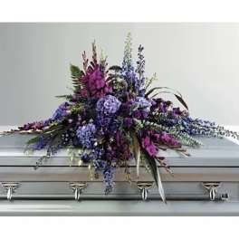 Purple and blue floral spray on a silver casket
